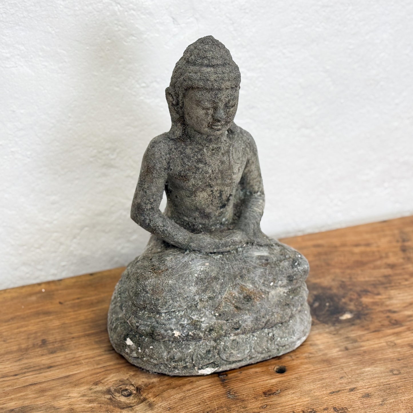 Stone Buddha statue on a wooden surface 