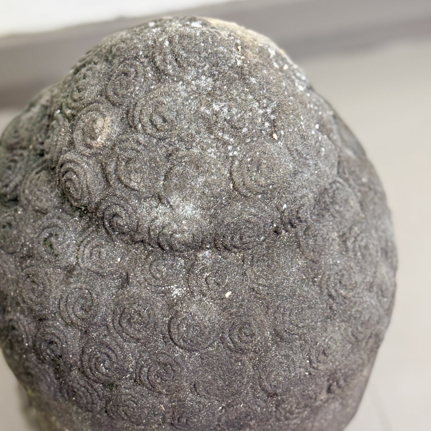 Decorative stone with textured surface and silver glitter on a white background