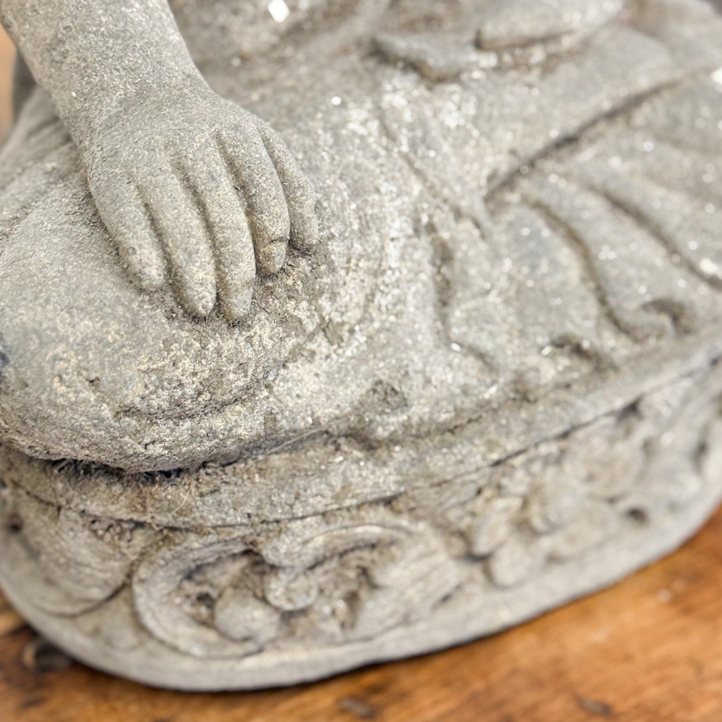 Close-up of a stone sculpture of a child on a wooden surface