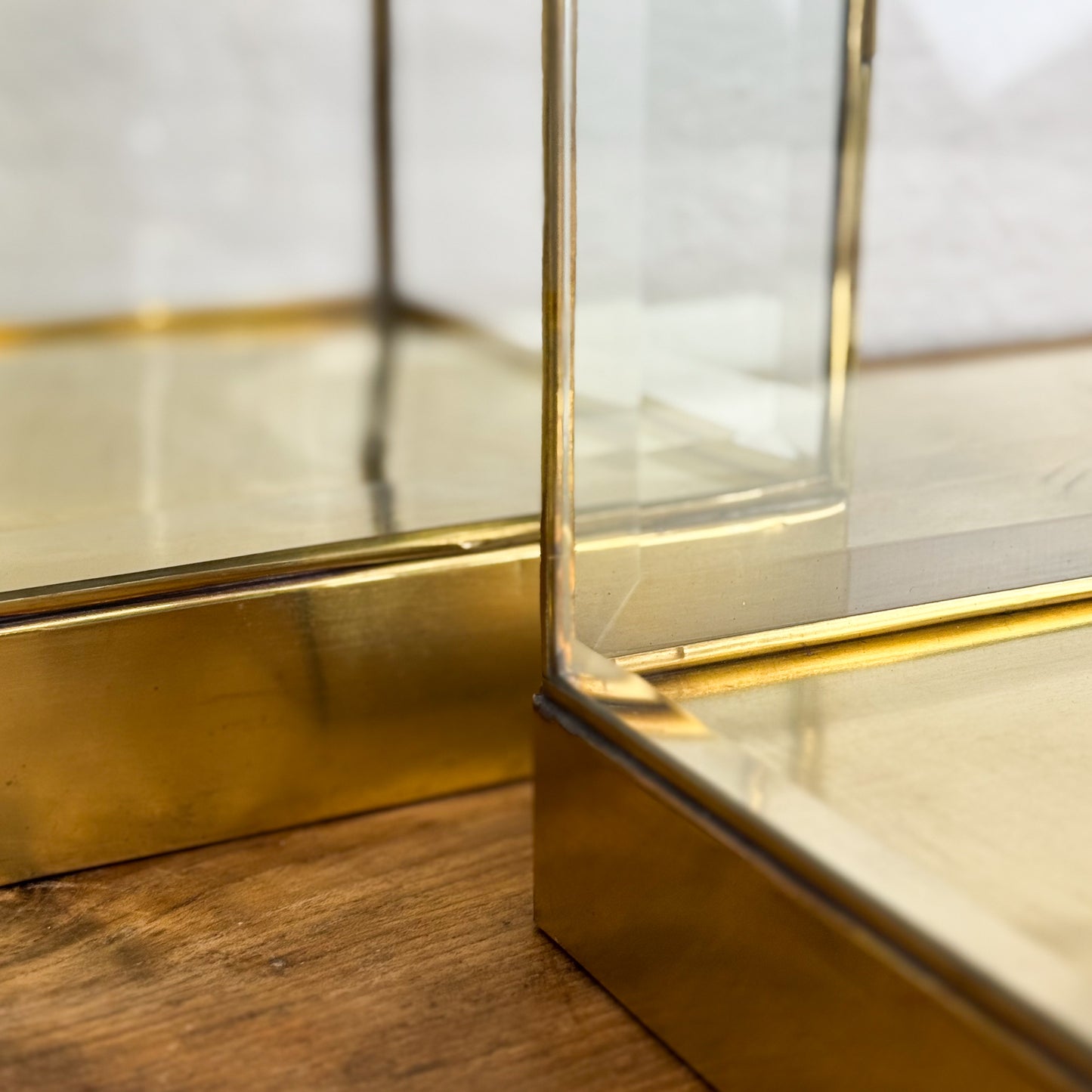 Gold-framed glass display case on a wooden surface