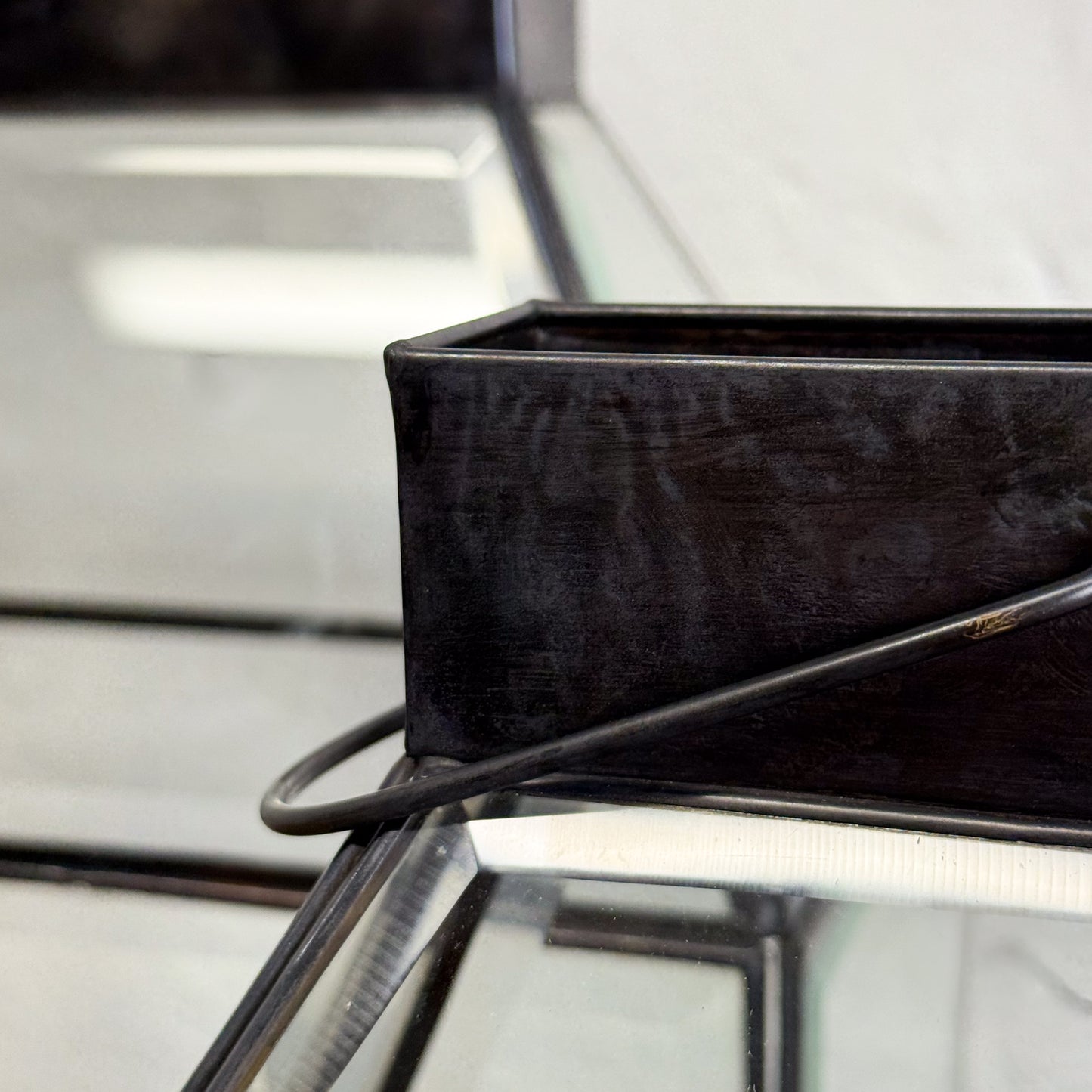 Black rectangular tray on a reflective surface with blurred background