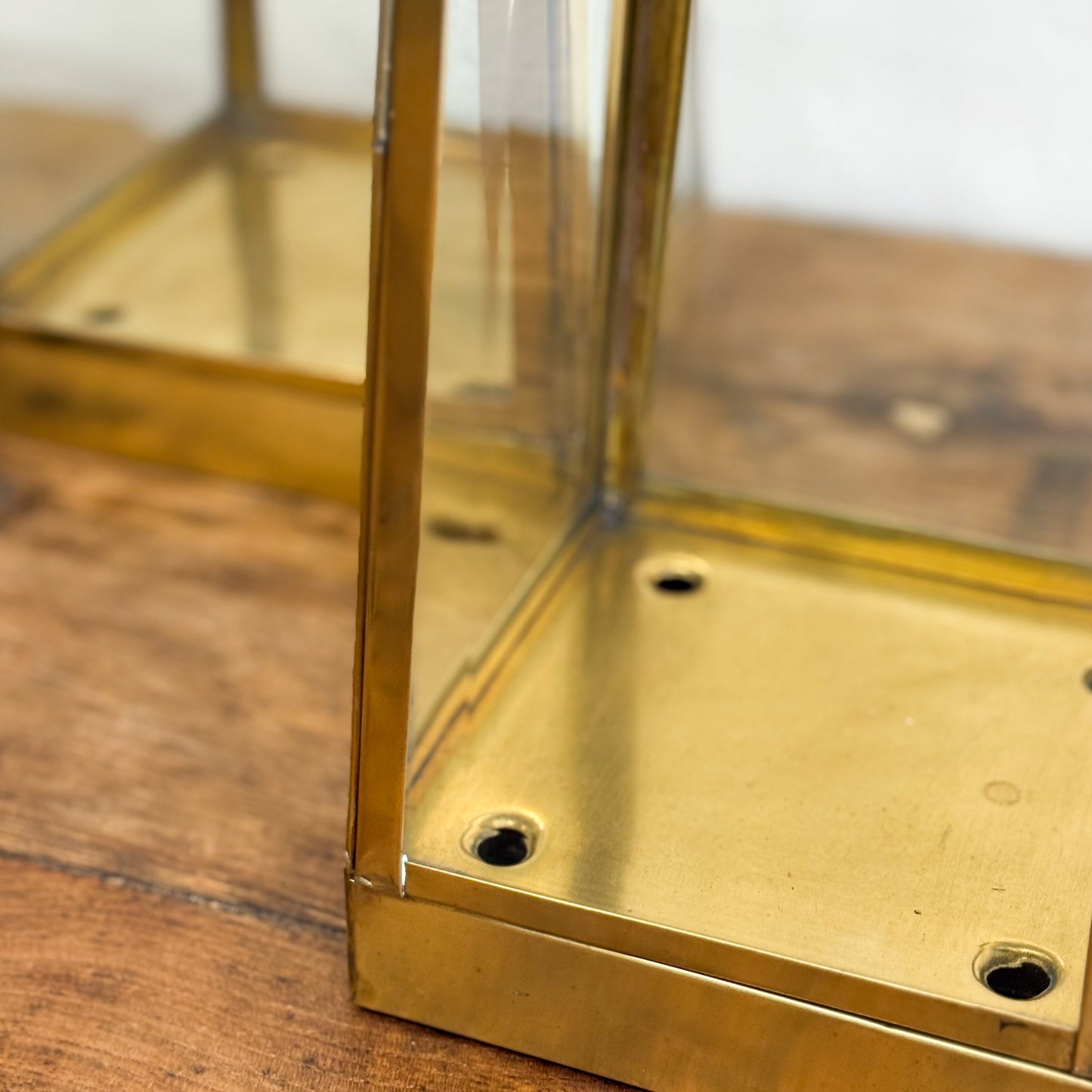 Brass box with glass sides on a wooden surface