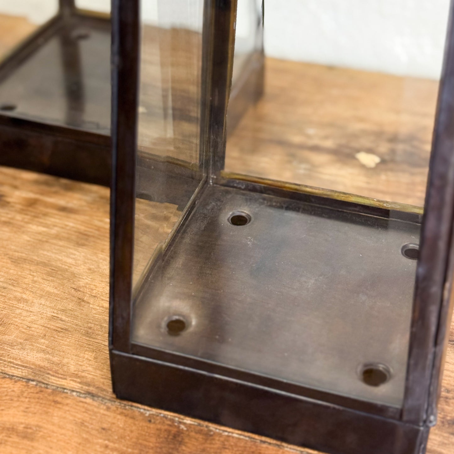 Close-up of a metal and glass container on a wooden surface