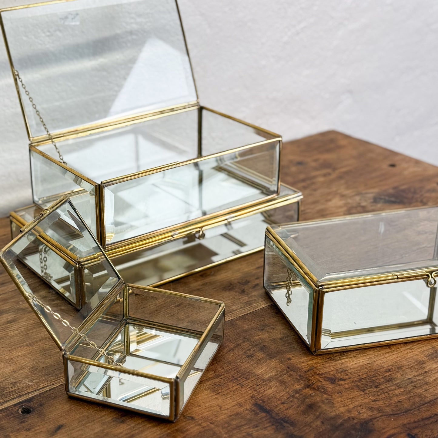 Set of glass boxes with gold trim on a wooden surface