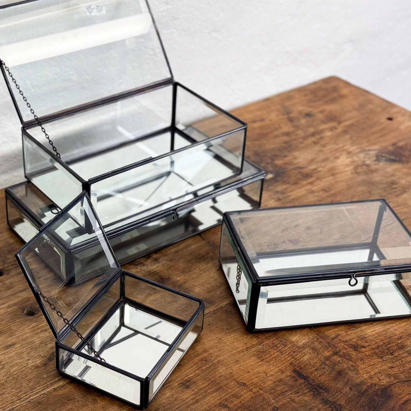 Set of glass jewelry boxes on a wooden surface