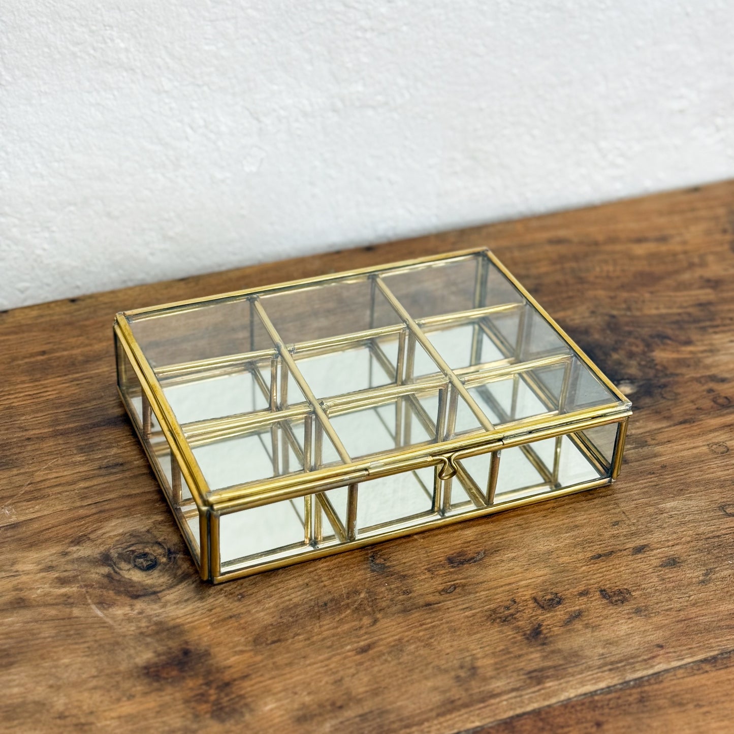 Glass box with gold frame on a wooden surface