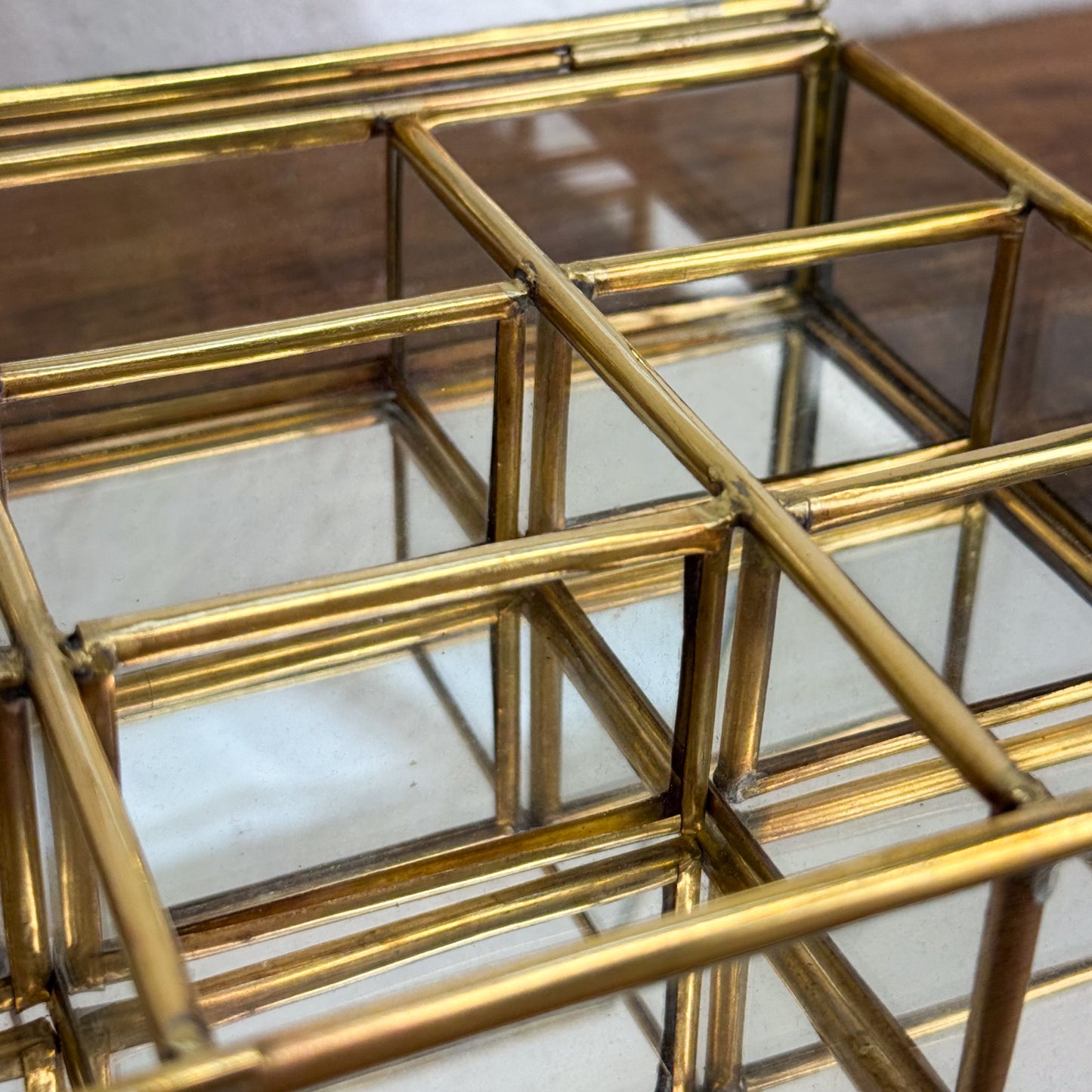 Gold geometric glass display case on a white background