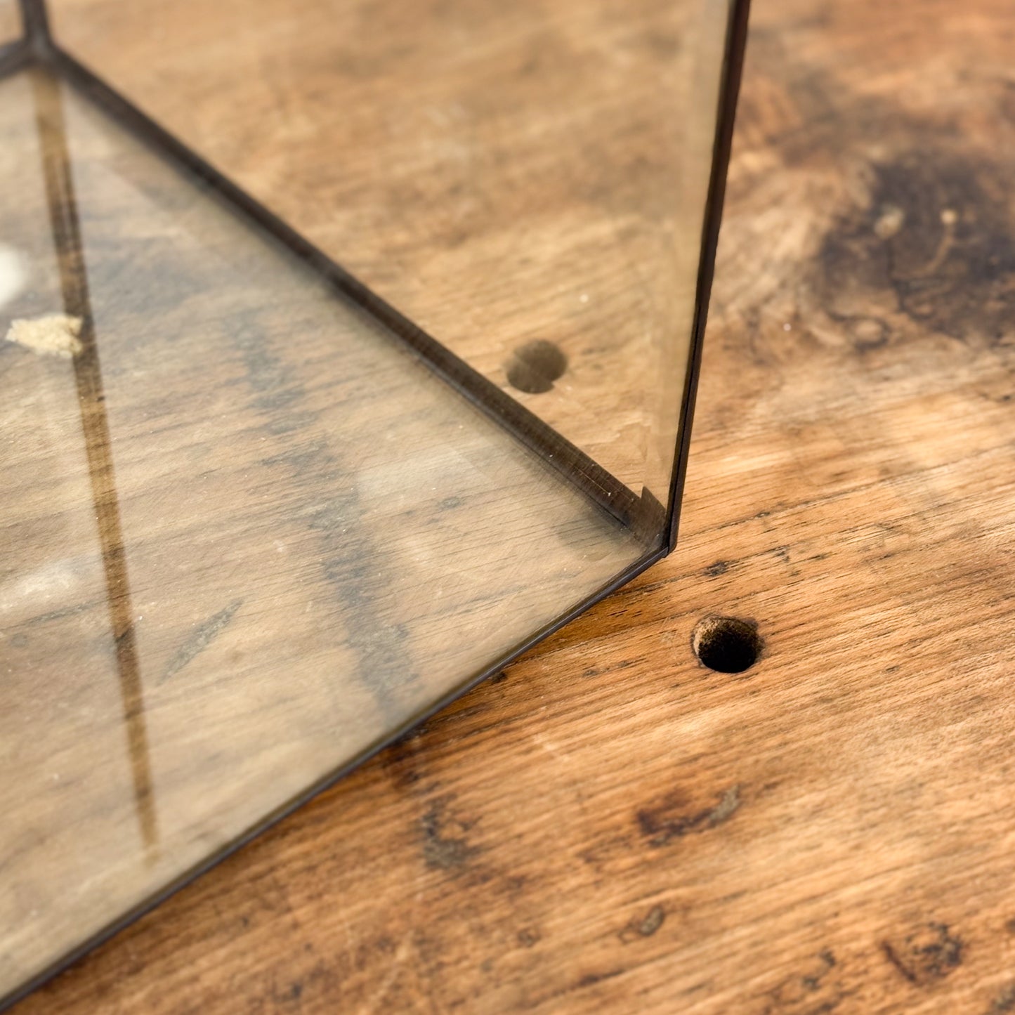 Close-up of a wooden surface with a glass panel