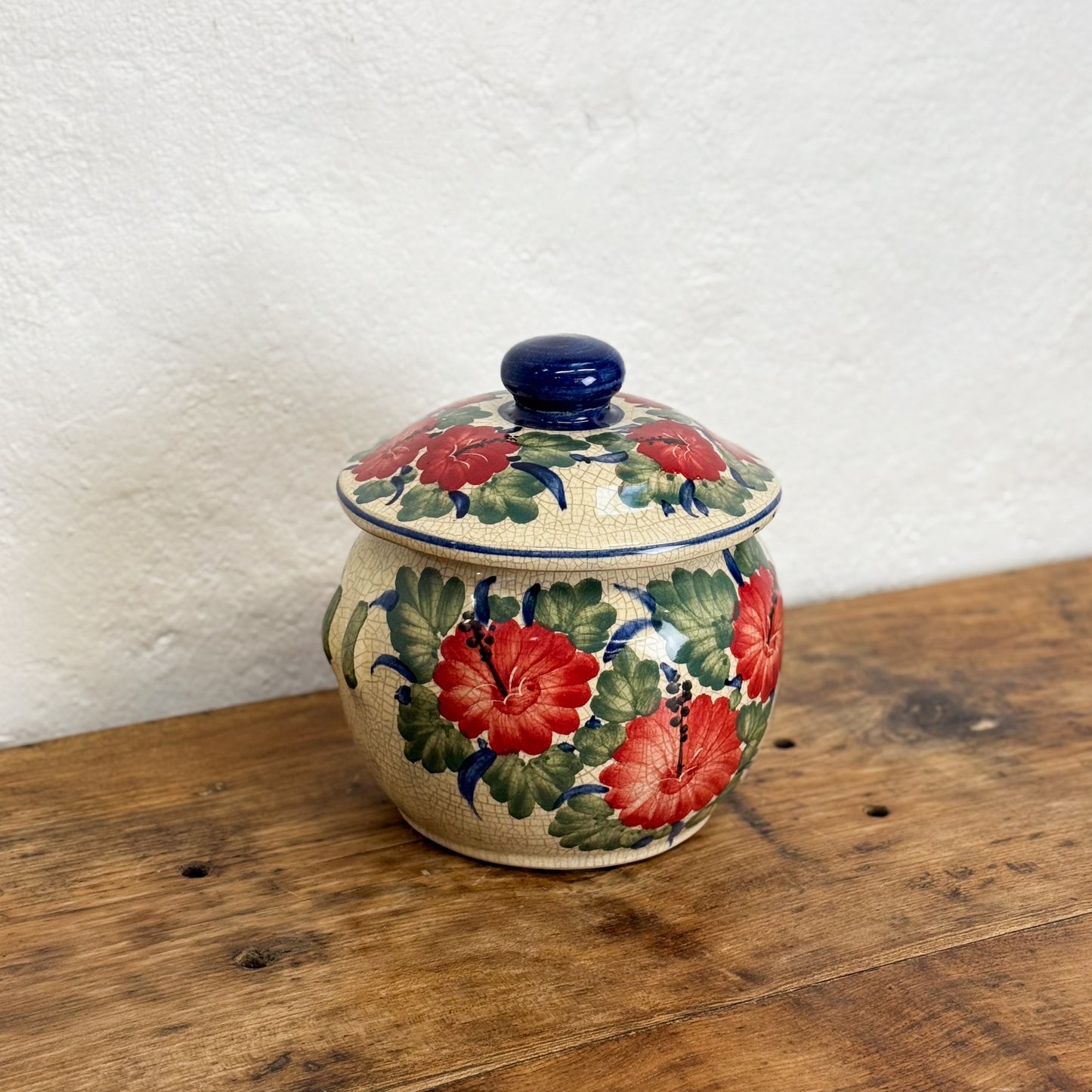 Decorative ceramic jar with floral patterns on a wooden surface