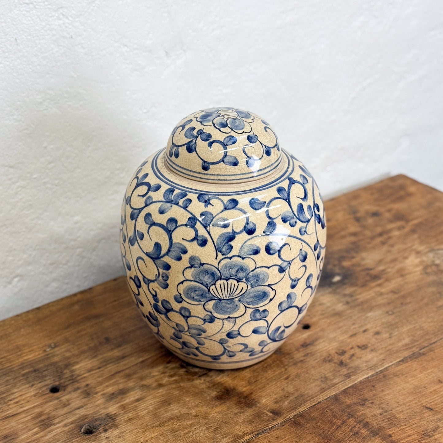 Ceramic jar with blue floral patterns on a wooden surface