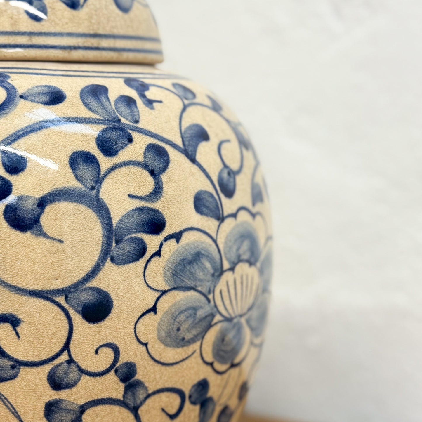 Close-up of a ceramic jar with blue floral patterns on a plain background