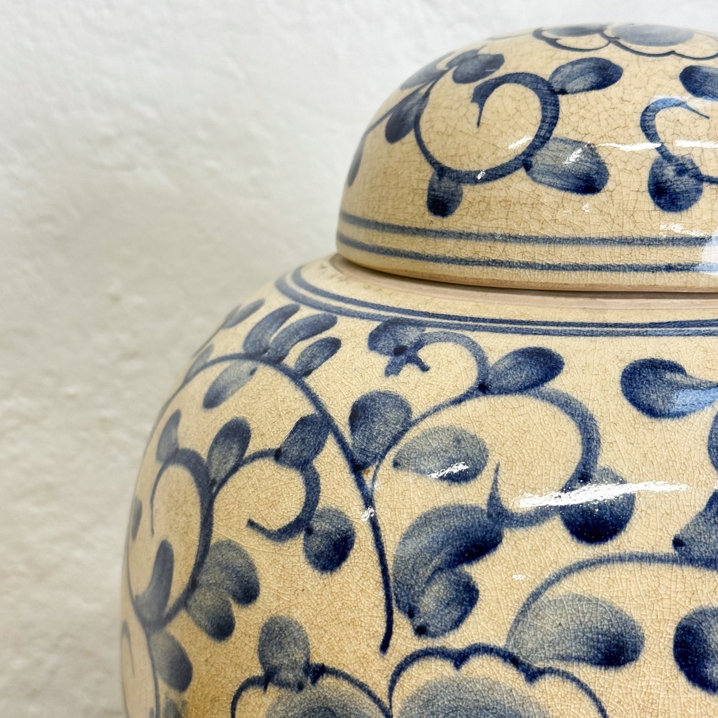 Ceramic jar with blue floral patterns on a beige background