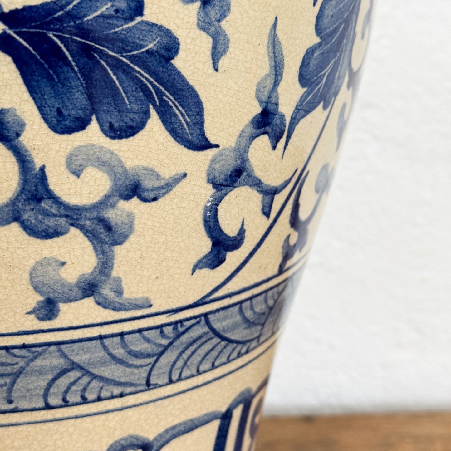 Close-up of a ceramic vase with blue floral patterns on a beige background