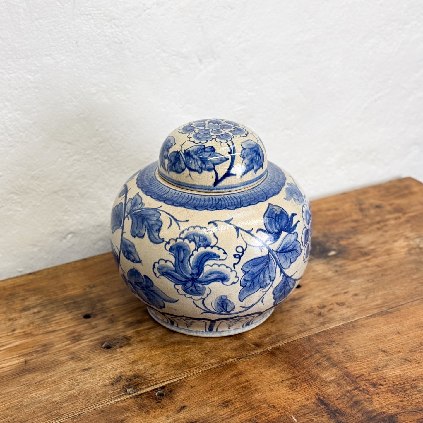 Ceramic jar with blue floral patterns on a wooden surface