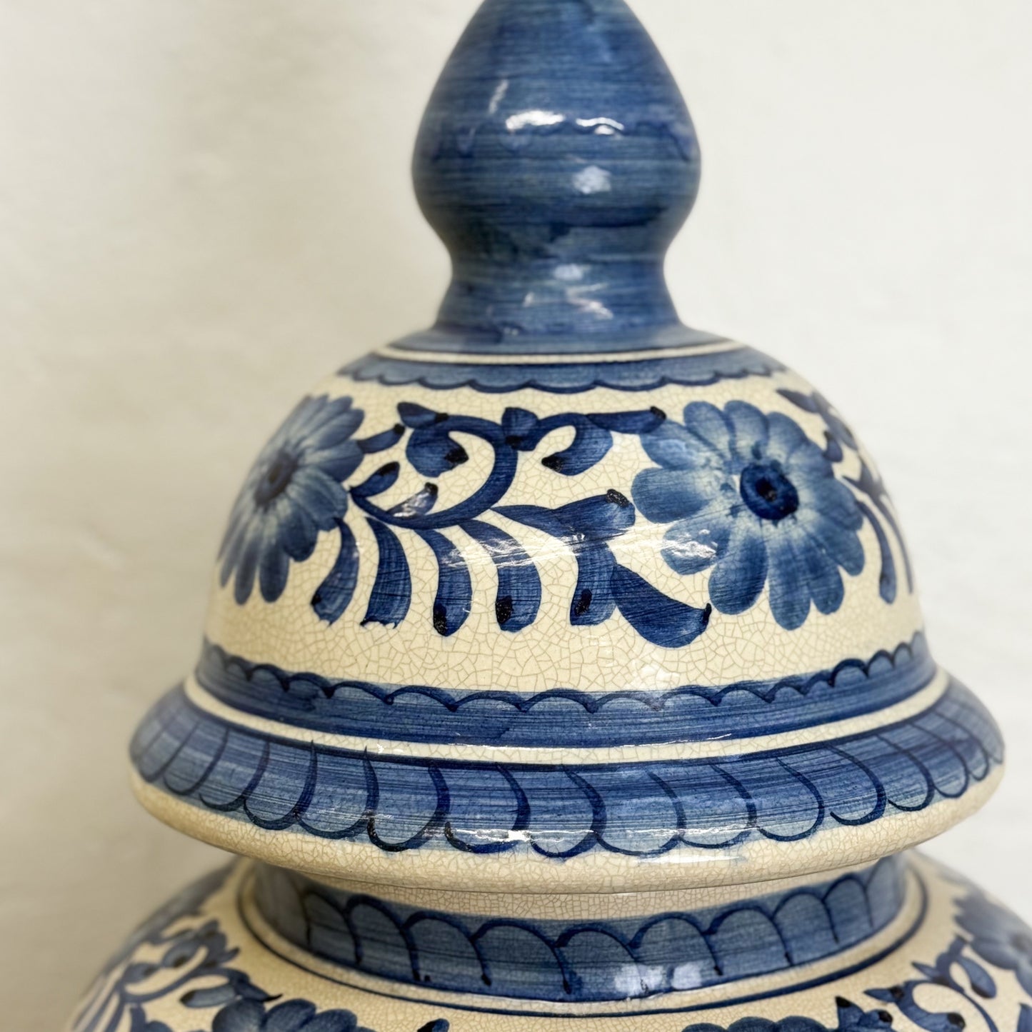 Ceramic jar with blue floral patterns on a beige background