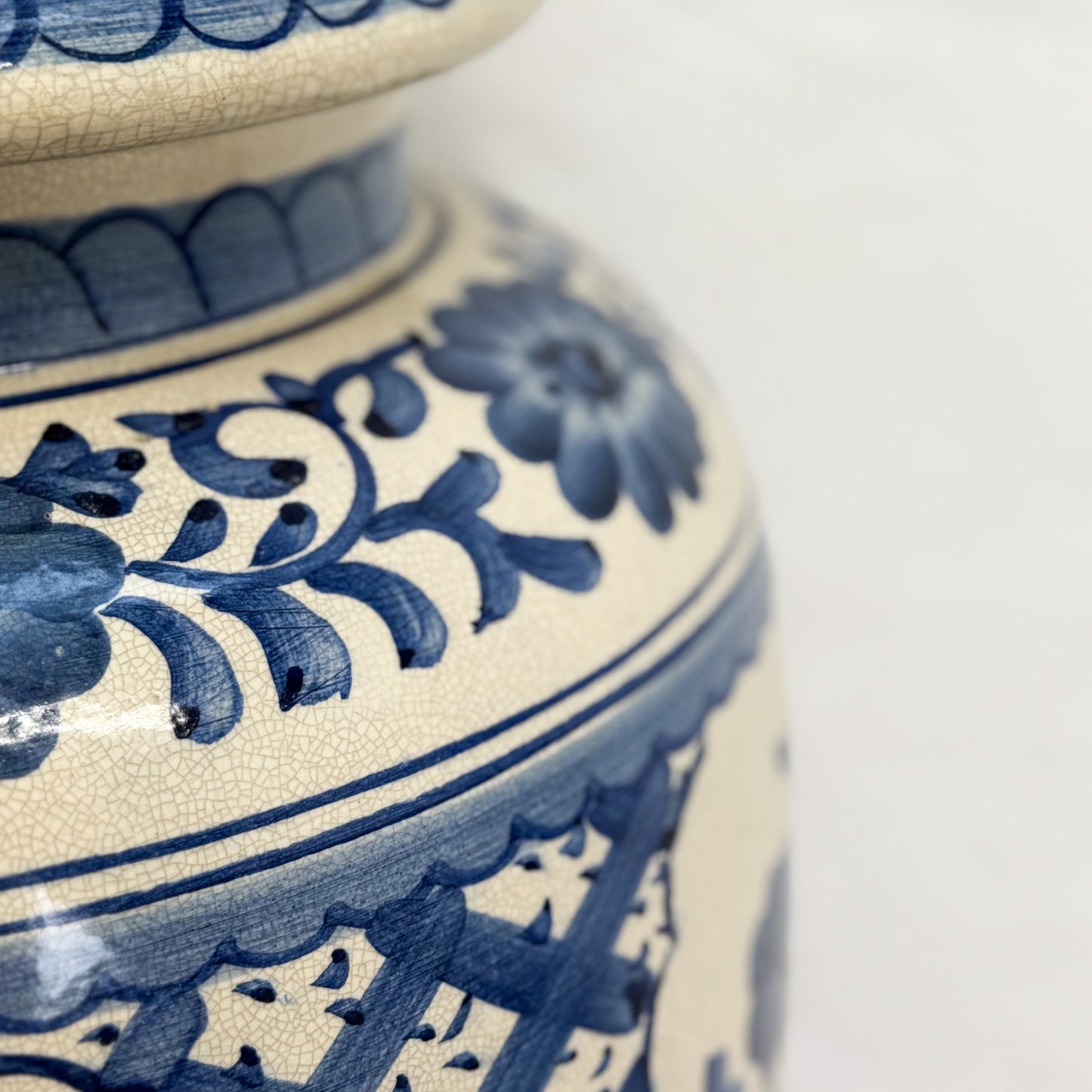 Close-up of a ceramic jar with blue floral patterns on a white background