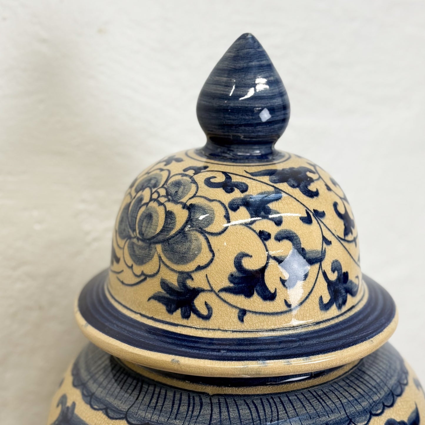 Ceramic jar with blue floral patterns on a beige background