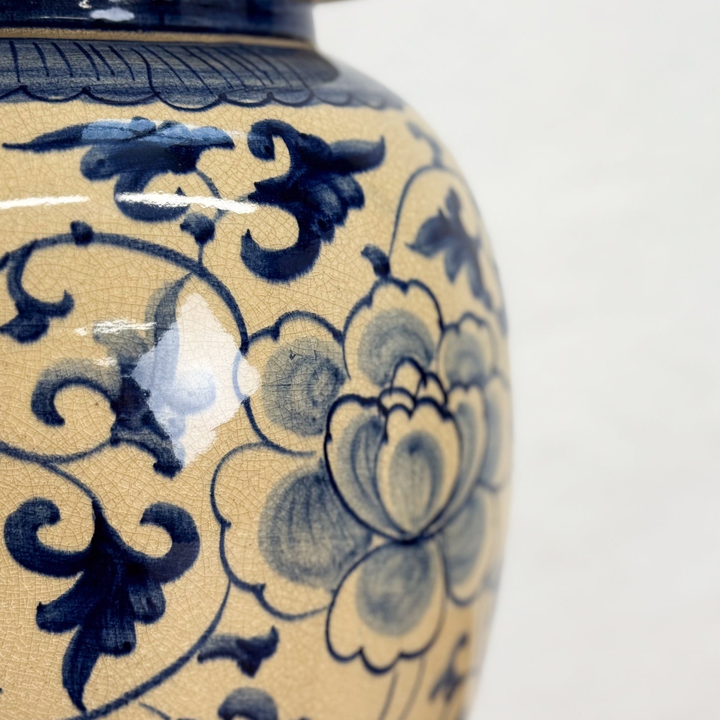 Close-up of a ceramic vase with blue floral patterns on a beige background