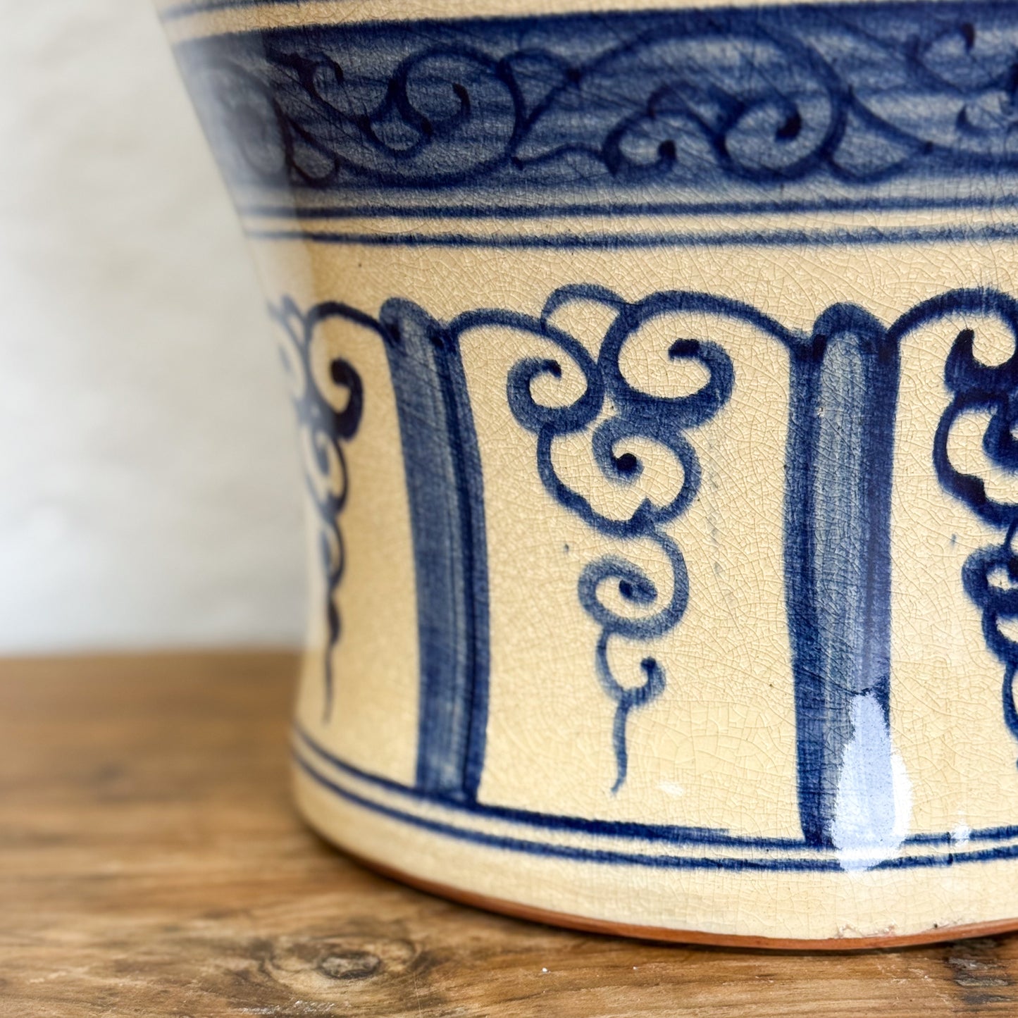 Ceramic vase with blue decorative patterns on a wooden surface