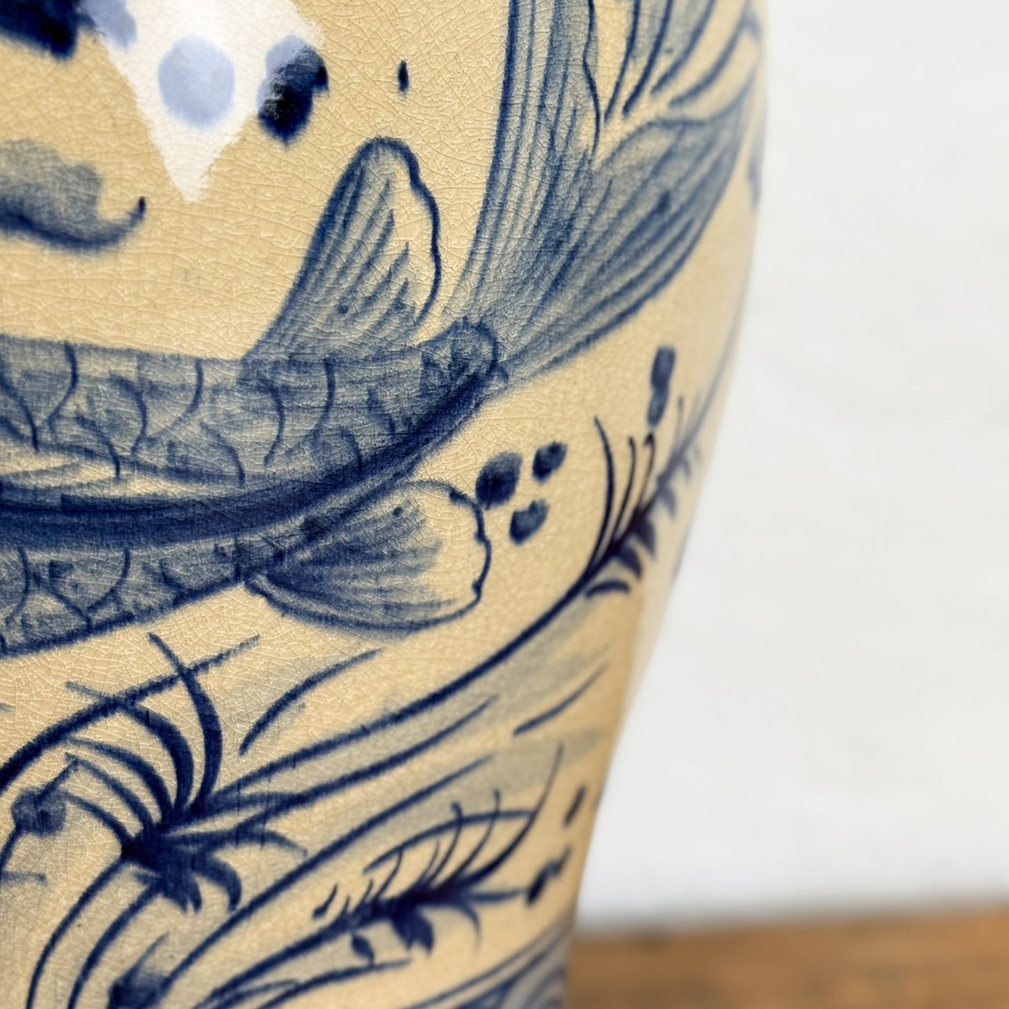 Close-up of a ceramic vase with blue floral patterns on a beige background