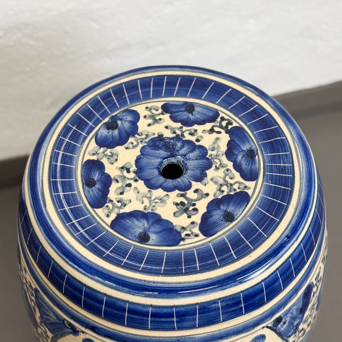 Ceramic stool with blue floral design on a white background