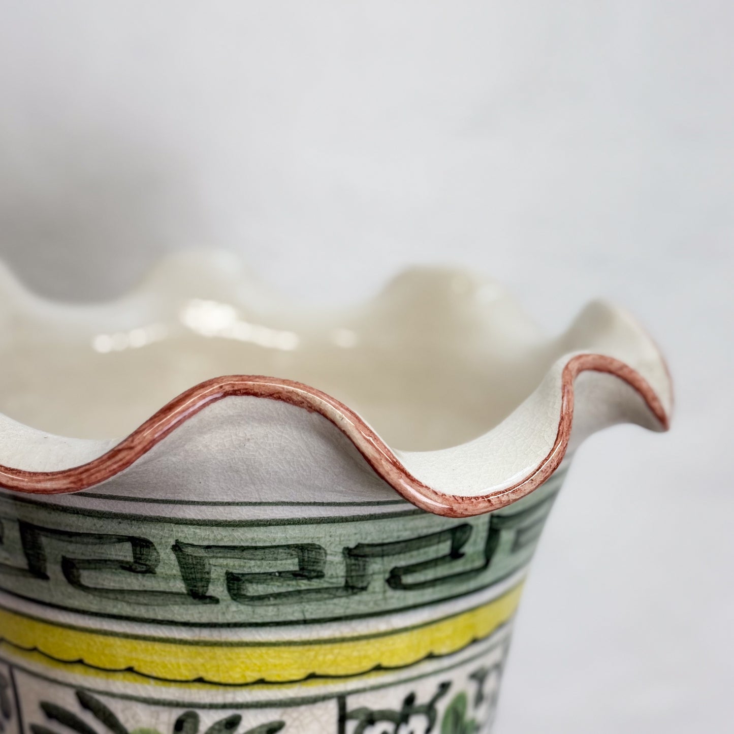 Close-up of a ceramic vase with decorative patterns on a white background