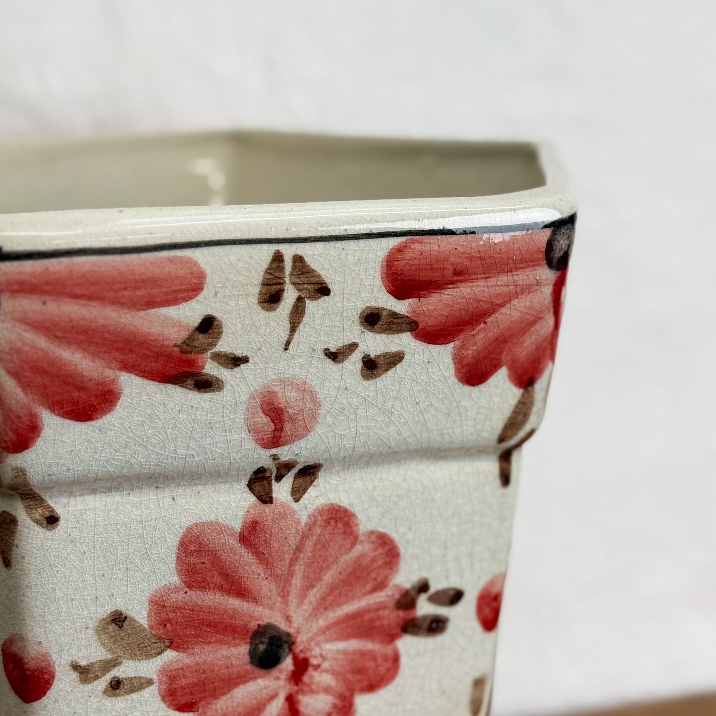 Ceramic planter with floral design on a white background