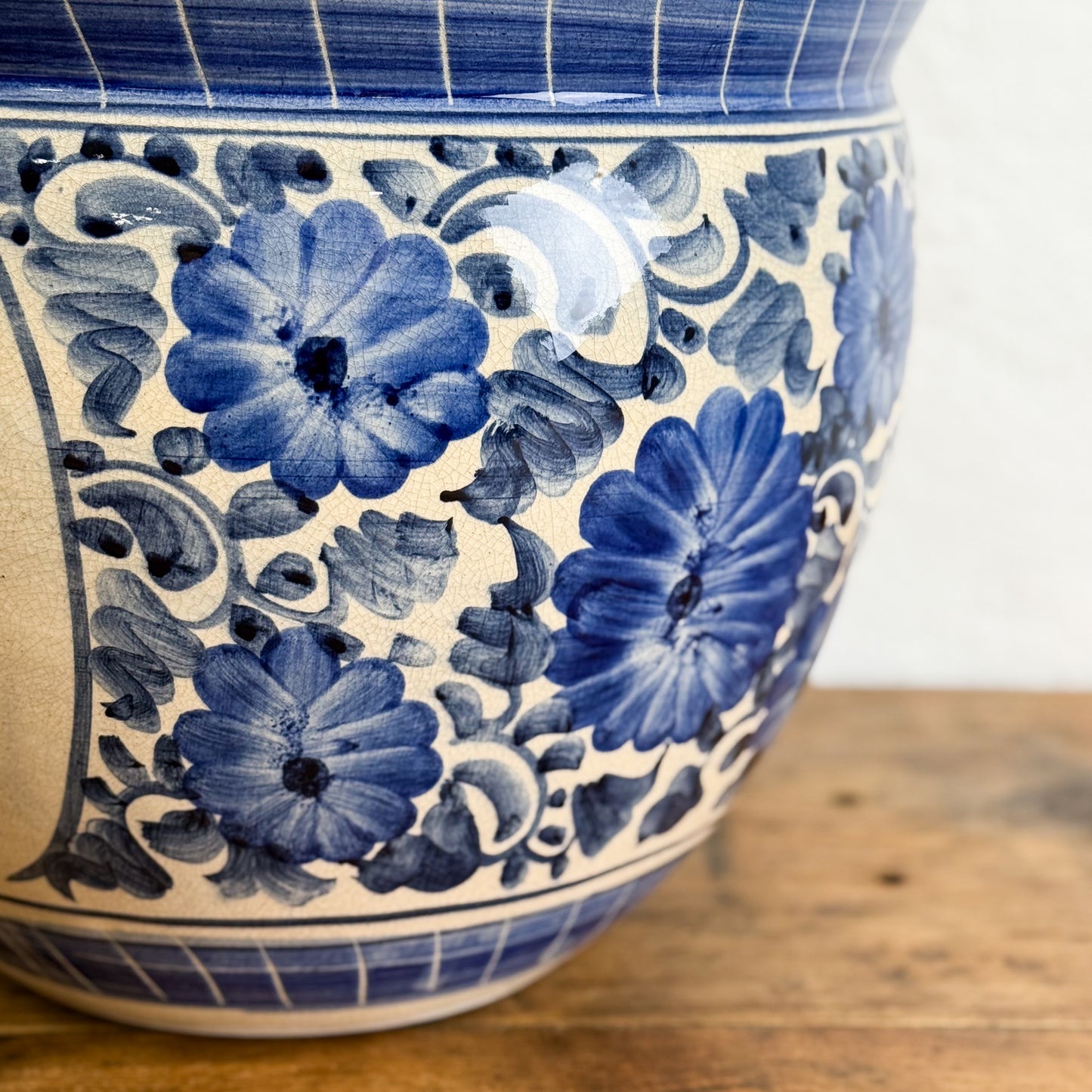 Blue floral pattern on a ceramic vase against a white background