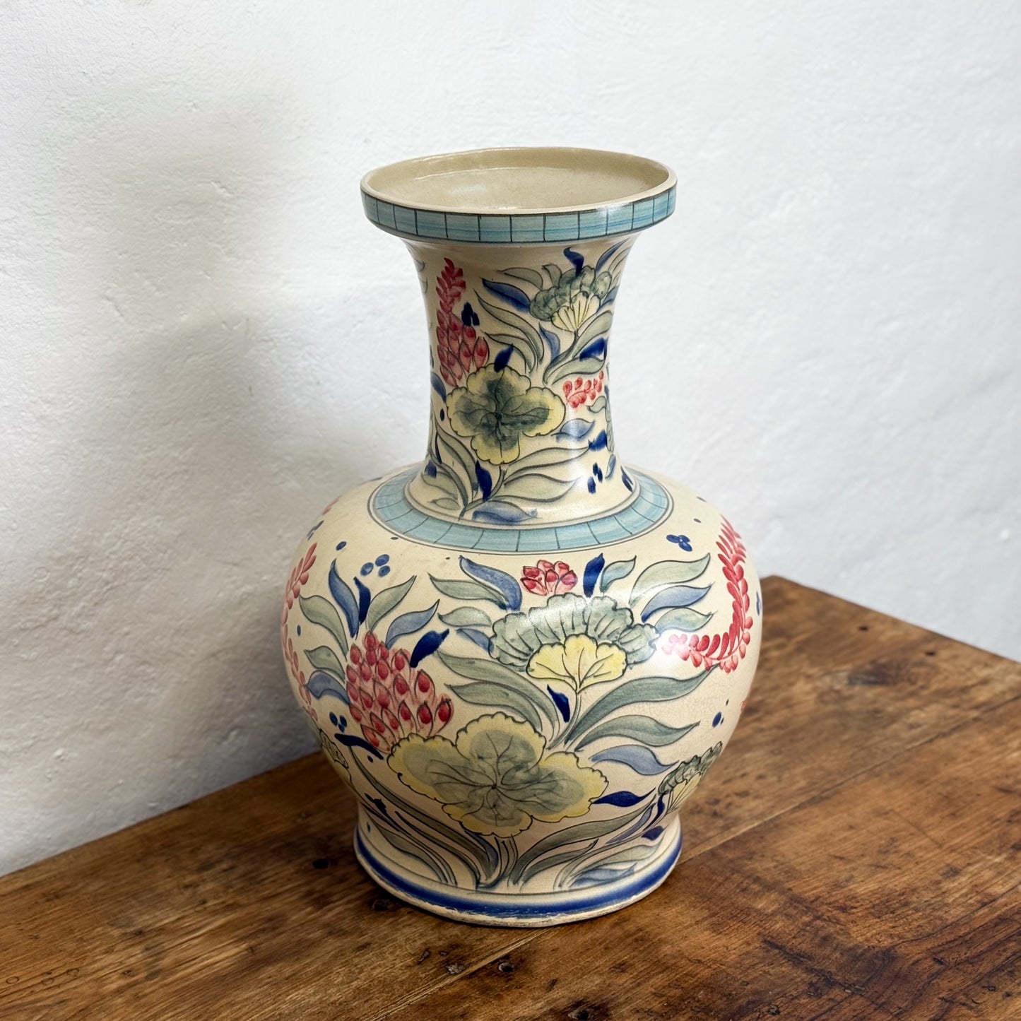 Decorative ceramic vase with floral patterns on a wooden surface