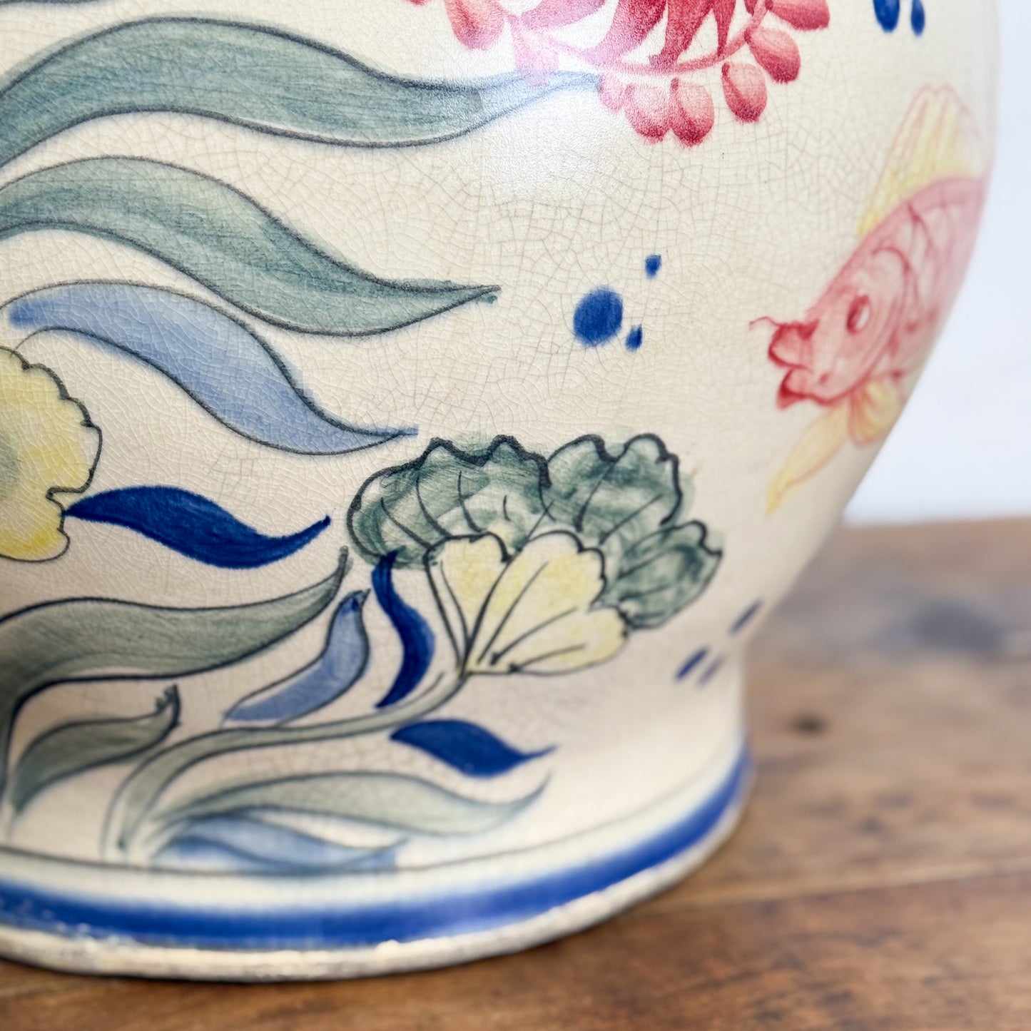 Ceramic vase with colorful floral design on a wooden surface