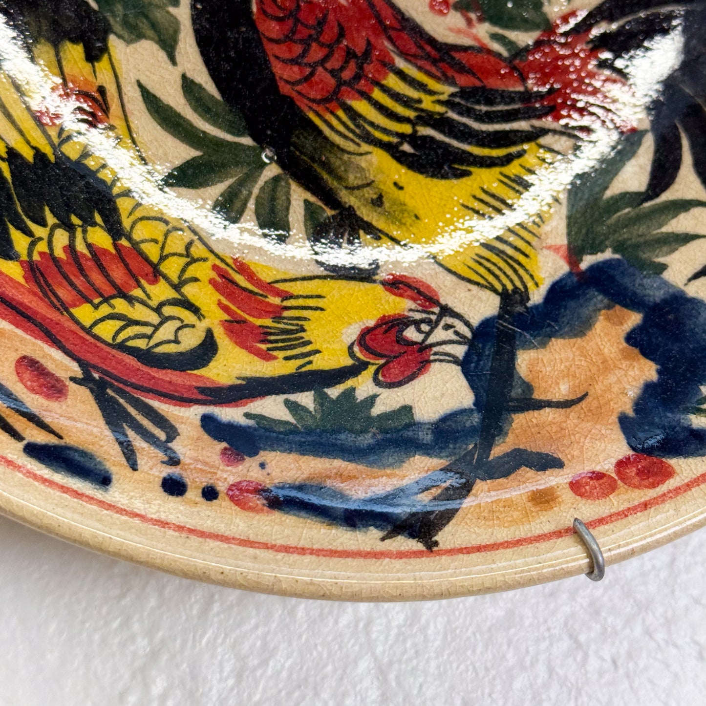 Ceramic plate with colorful bird design on a white background