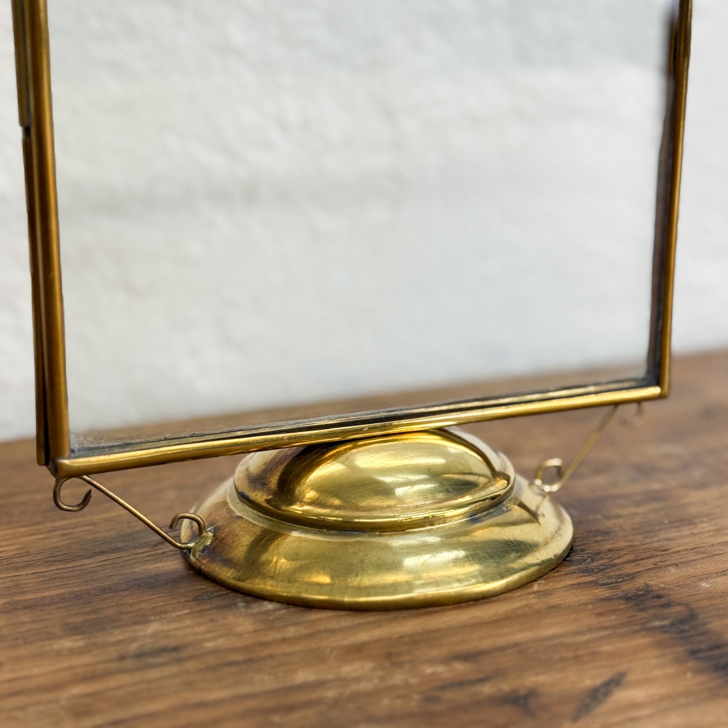 Brass magnifying glass on a wooden surface with a neutral background