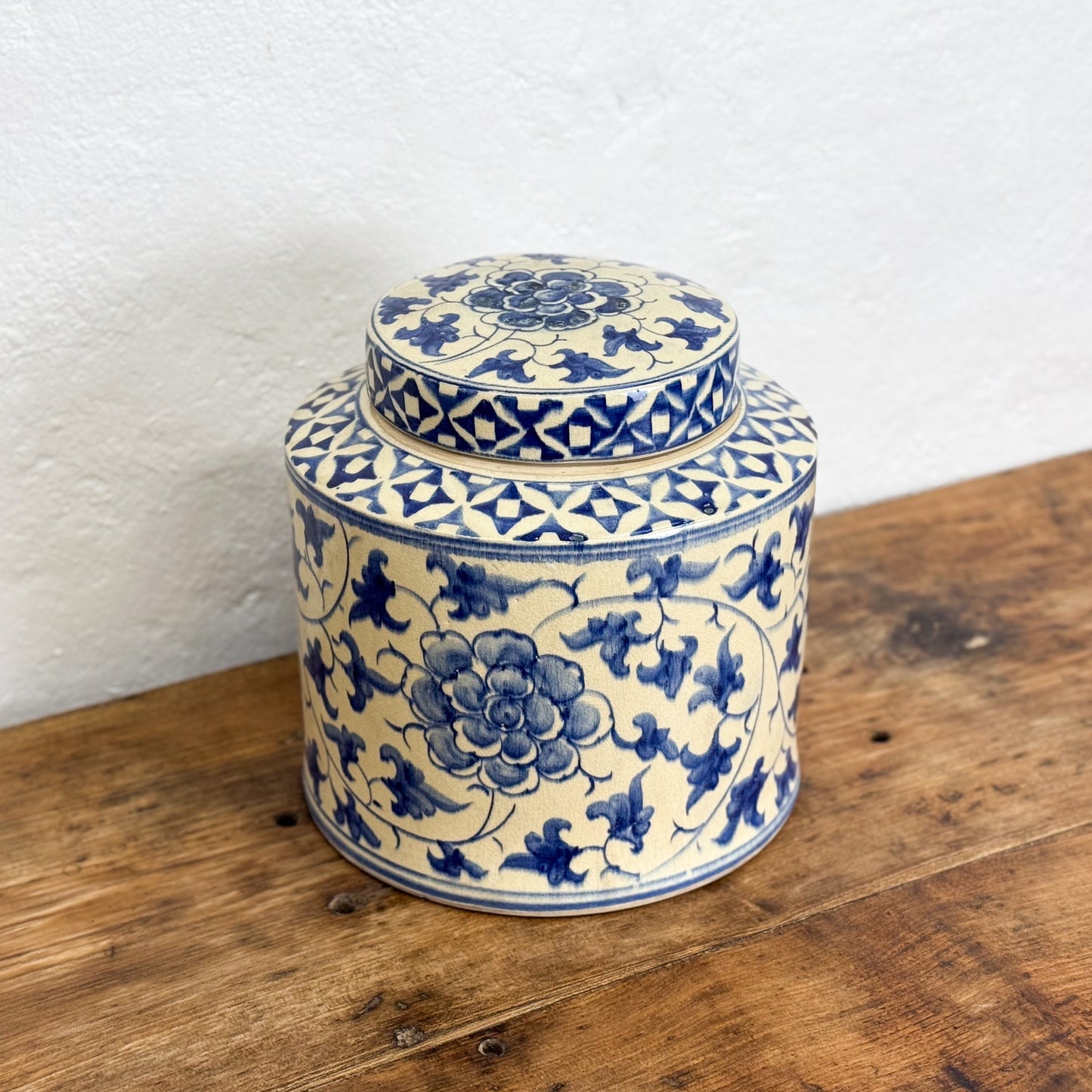 Ceramic jar with blue floral patterns on a wooden surface