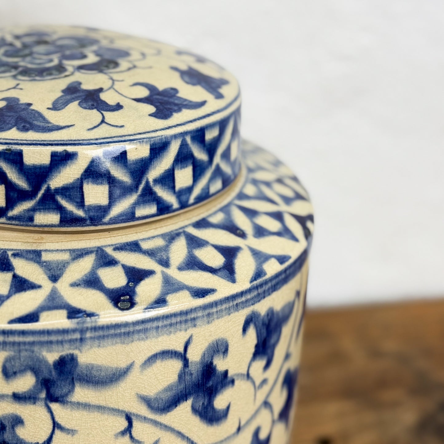 Blue and white patterned ceramic jar with lid on a blurred background