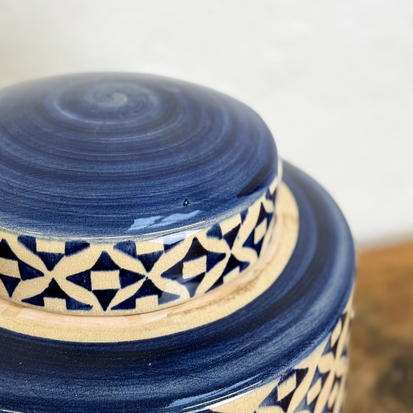 Blue ceramic jar with geometric pattern on a white background