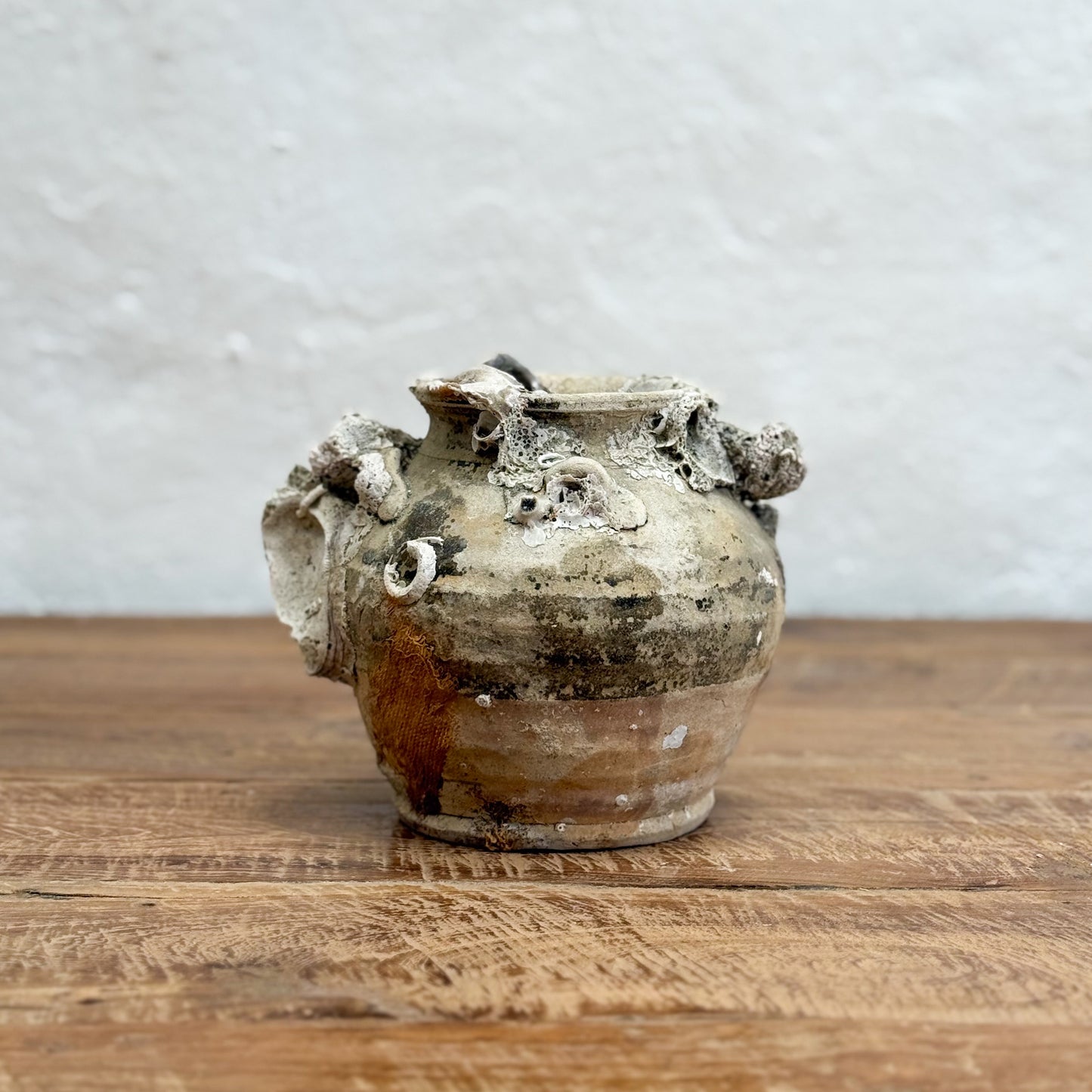 Vintage ceramic vase on a wooden surface with a gray textured background