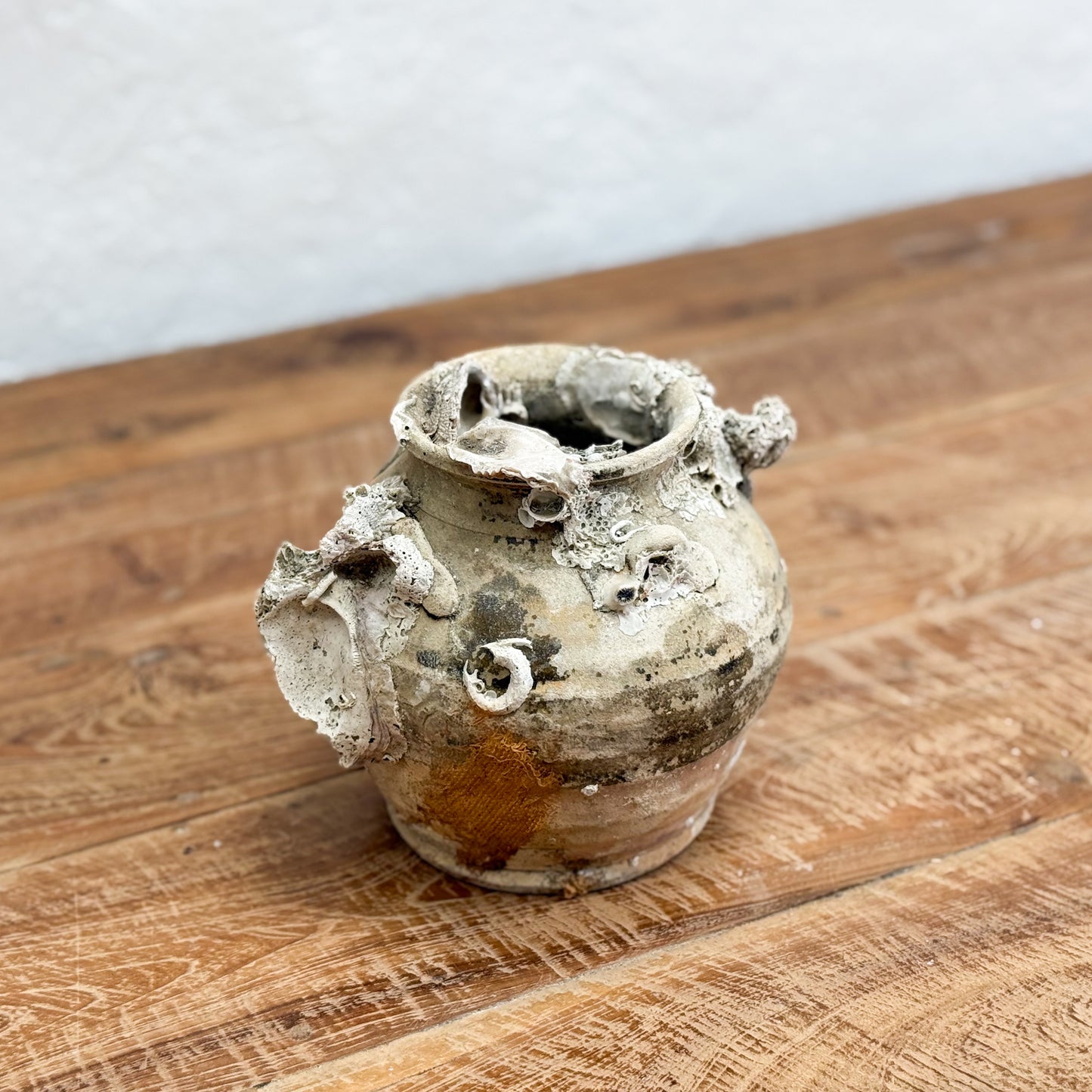 Vintage ceramic pot on a wooden surface with a white background