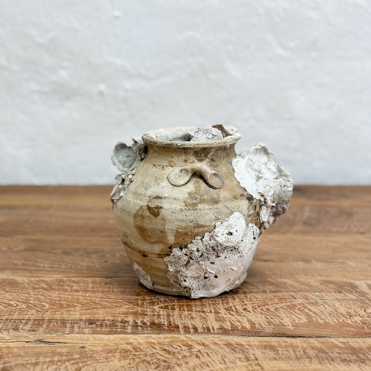 Vintage ceramic vase with textured surface on a wooden table