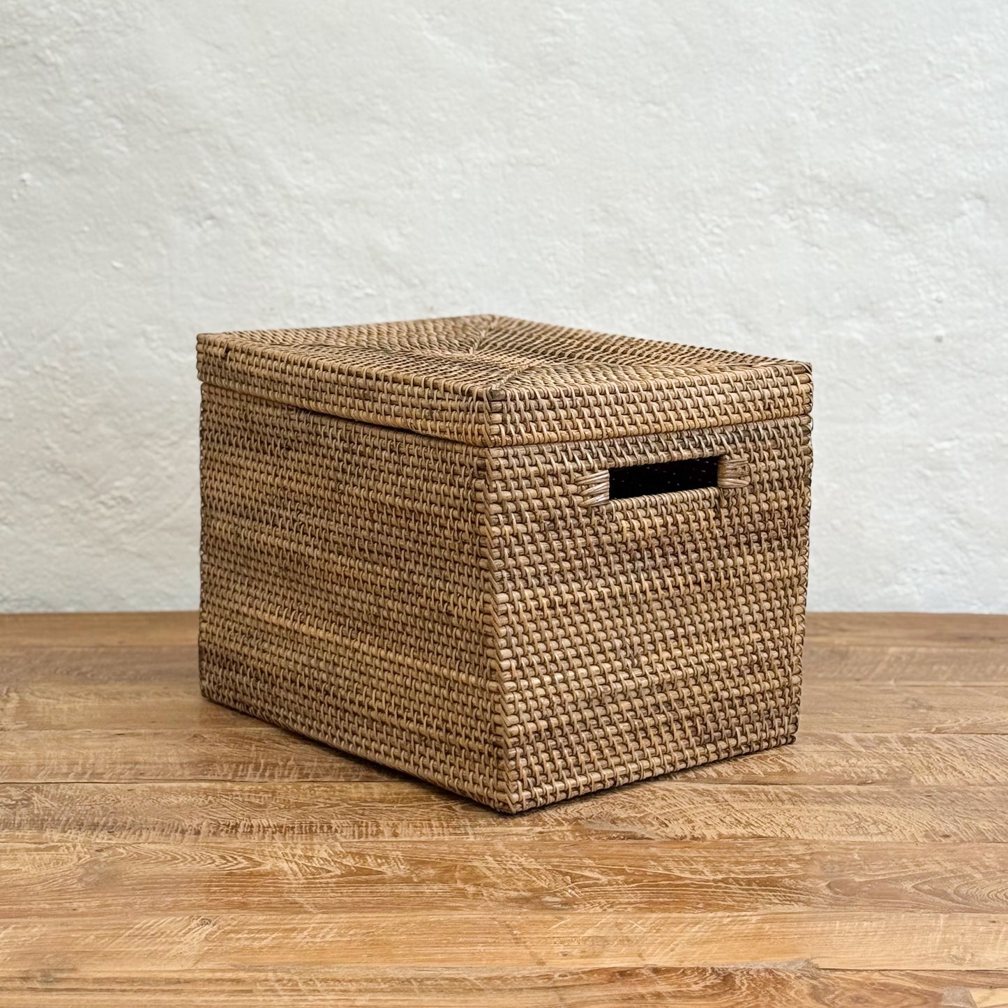 Woven storage basket with a lid on a wooden surface