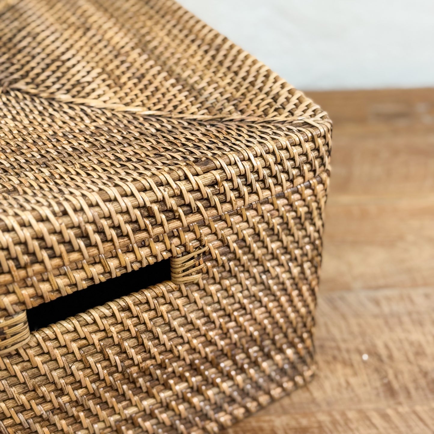 Woven basket with a black strip on a wooden surface