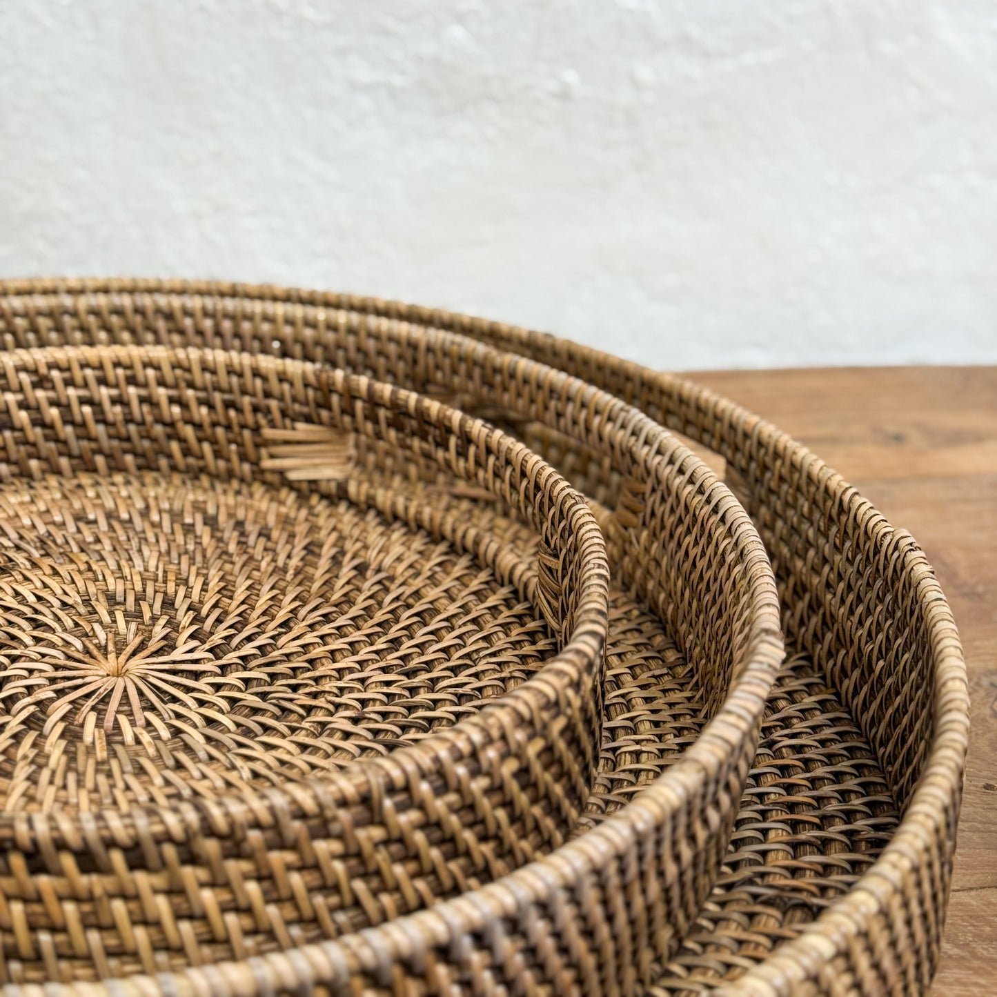 Set of woven baskets on a wooden surface with a neutral background