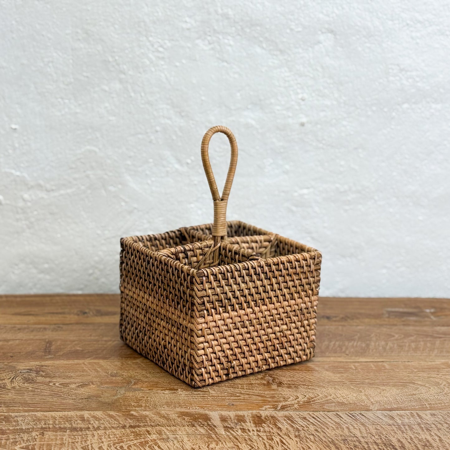Woven basket with a handle on a wooden surface