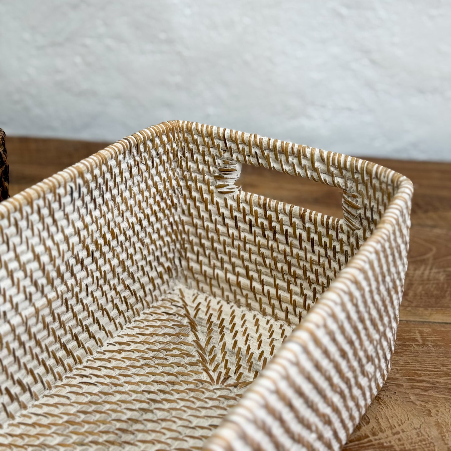 Woven basket with handles on a wooden surface