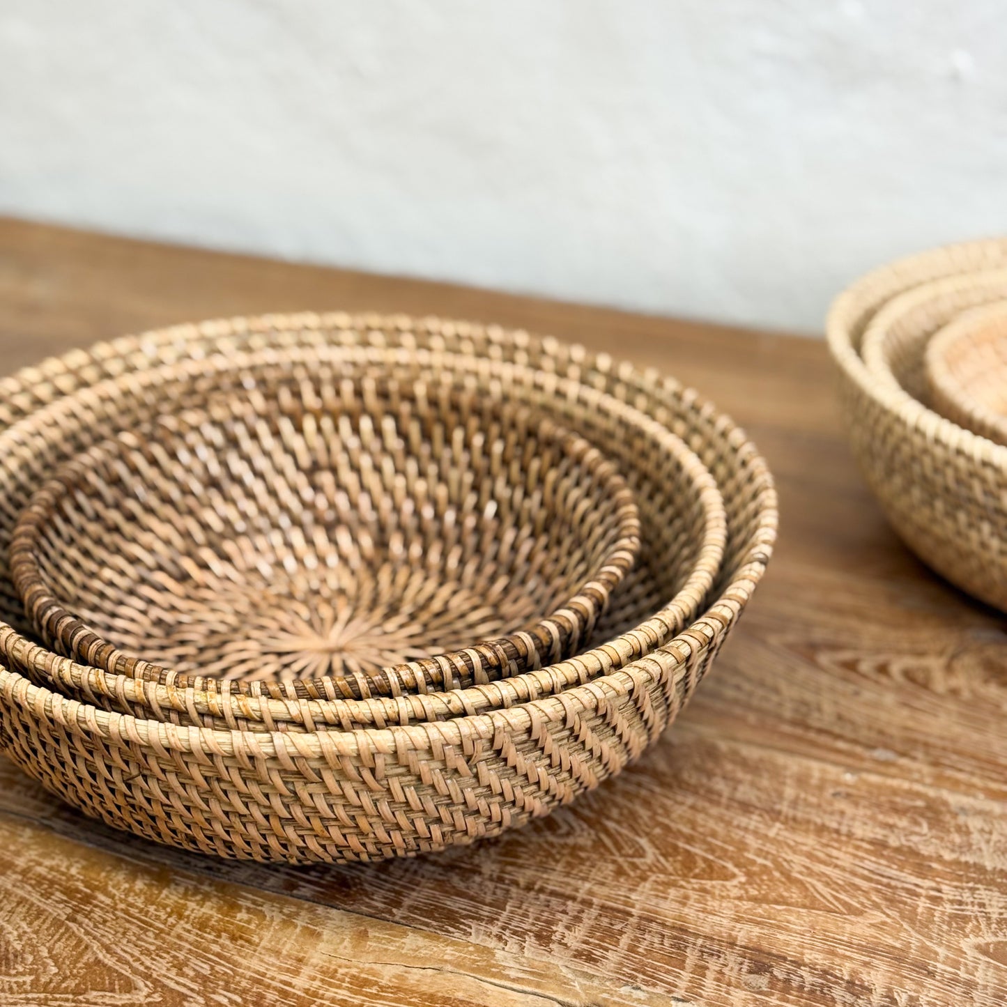 Set of woven baskets on a wooden surface with a blurred background