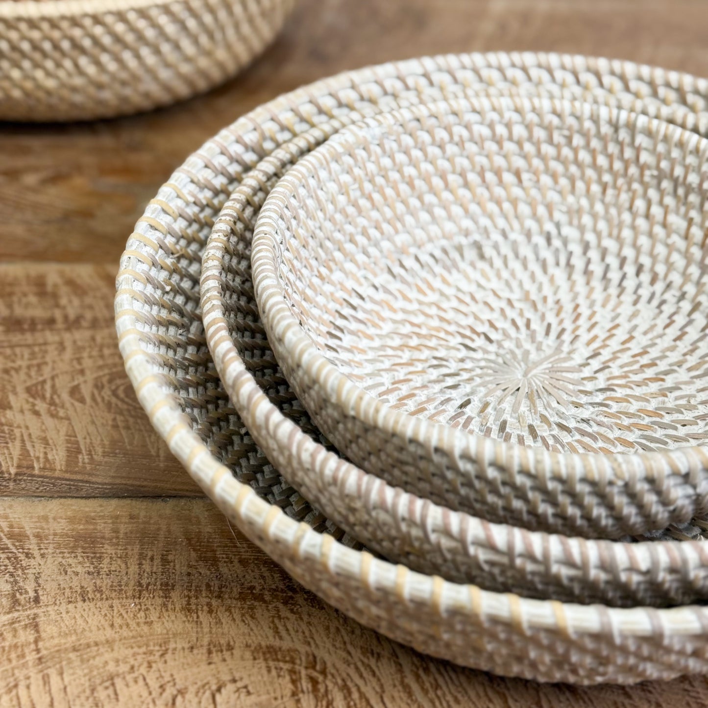 Stack of woven baskets on a wooden surface