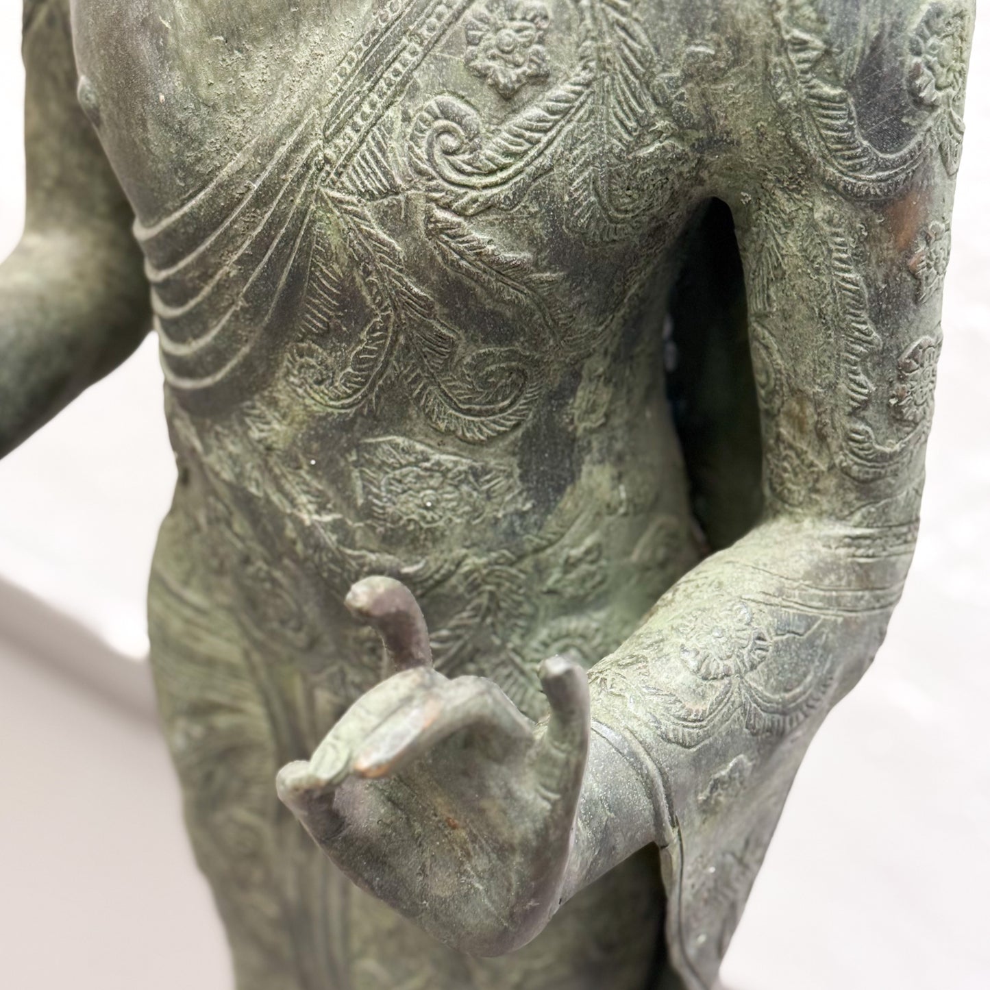 Bronze statue with intricate detailing on a white background