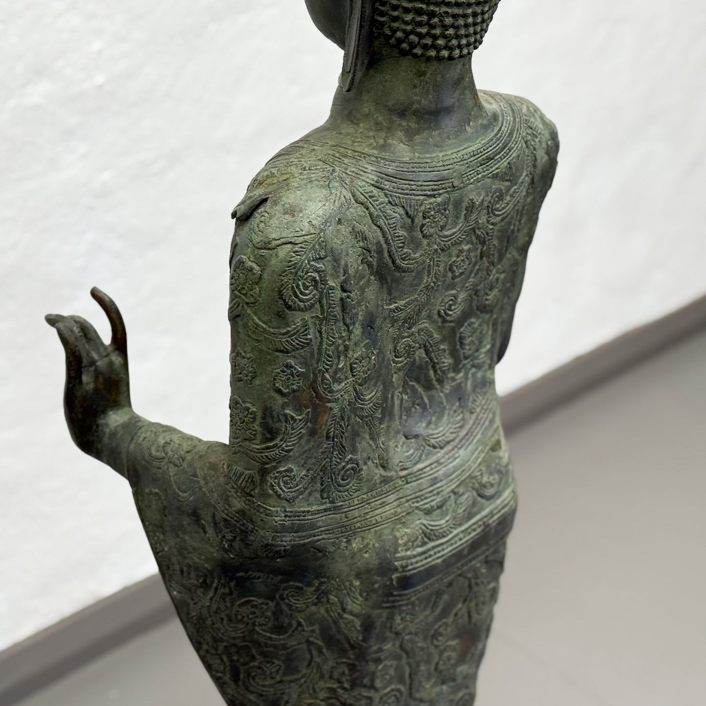 Bronze statue with intricate detailing on a white background