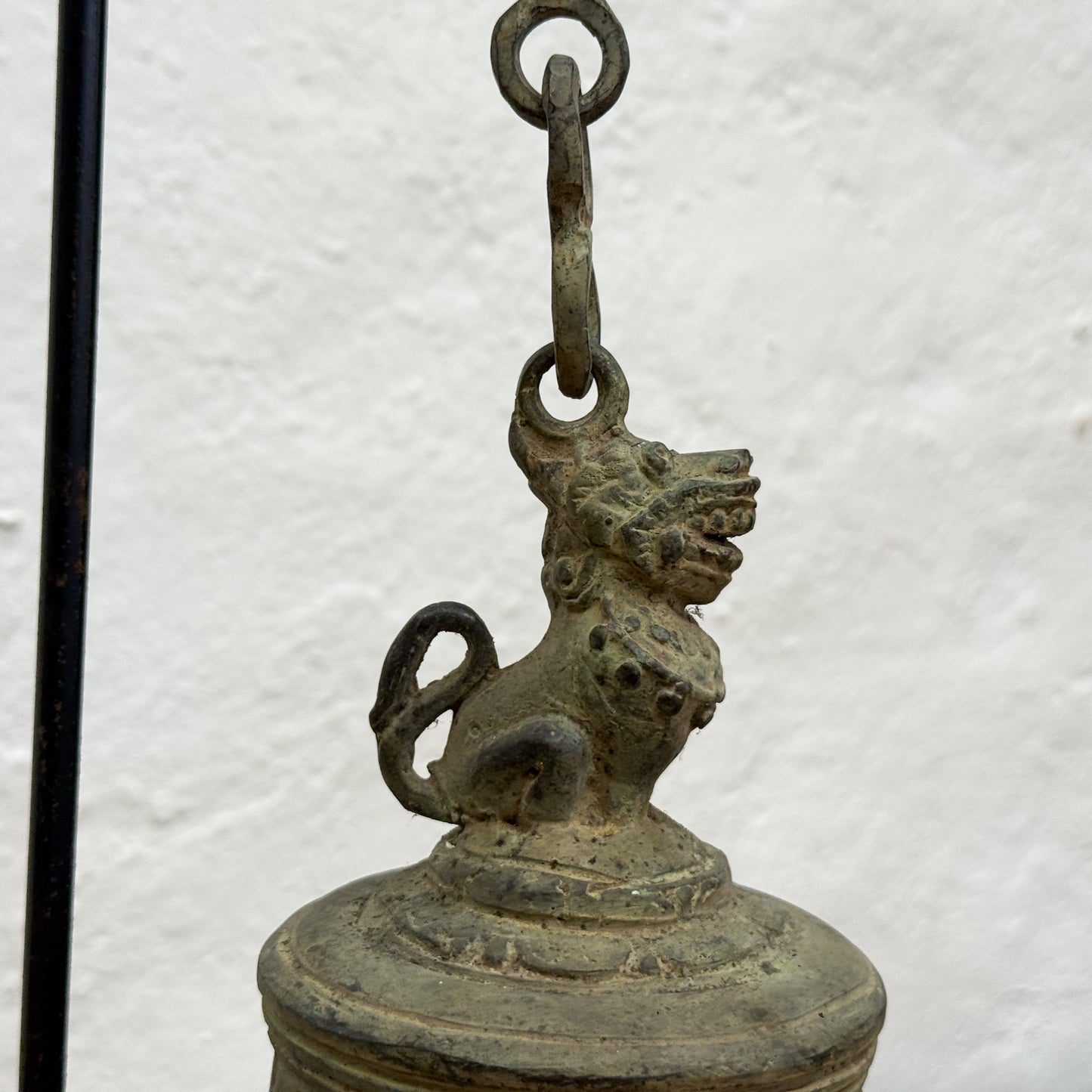 Bronze bell with a lion-like figure on a white background