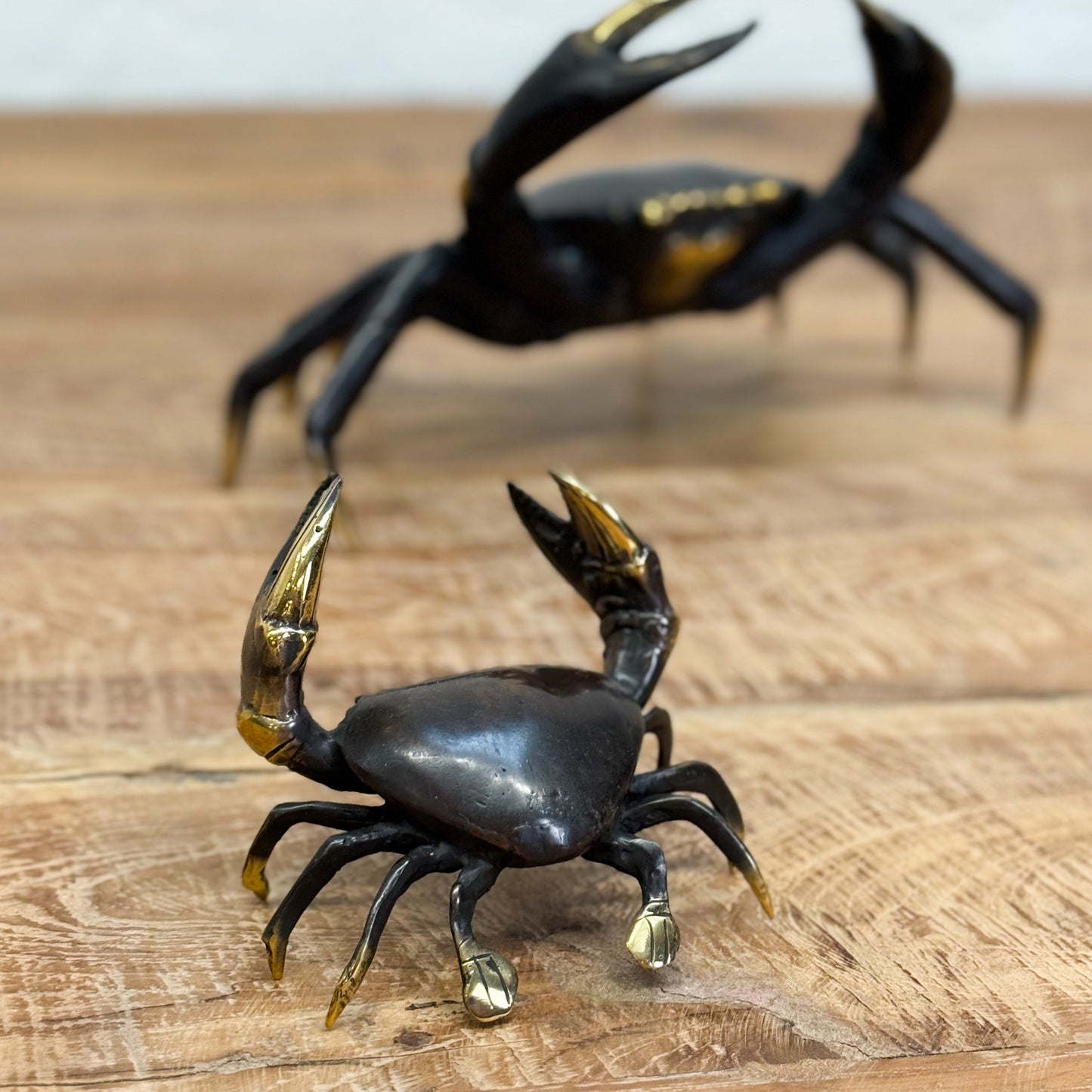 Black crab figurine with gold accents on a wooden surface