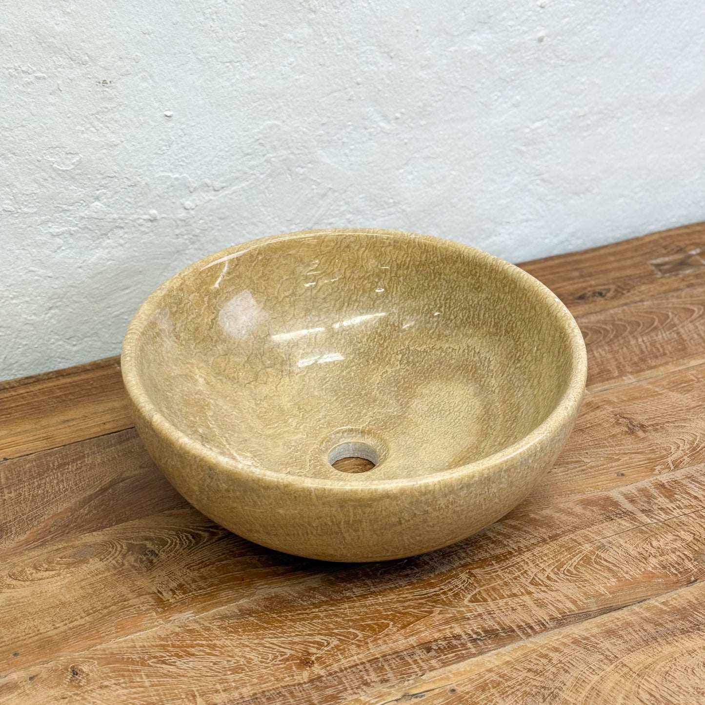 Beige ceramic bowl on a wooden surface with a light gray wall background